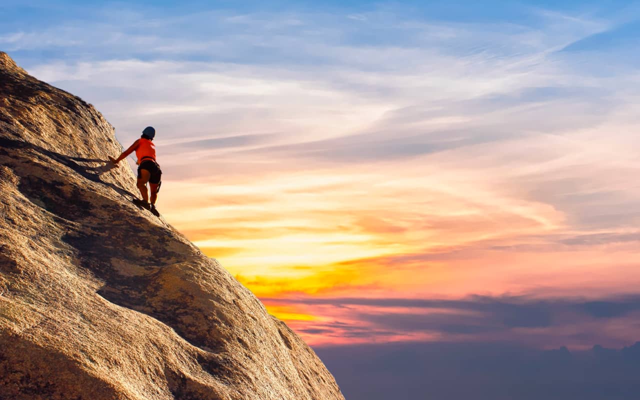 a woman climbing a mountain