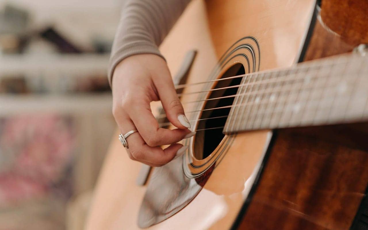 a woman is playing with guitar strings