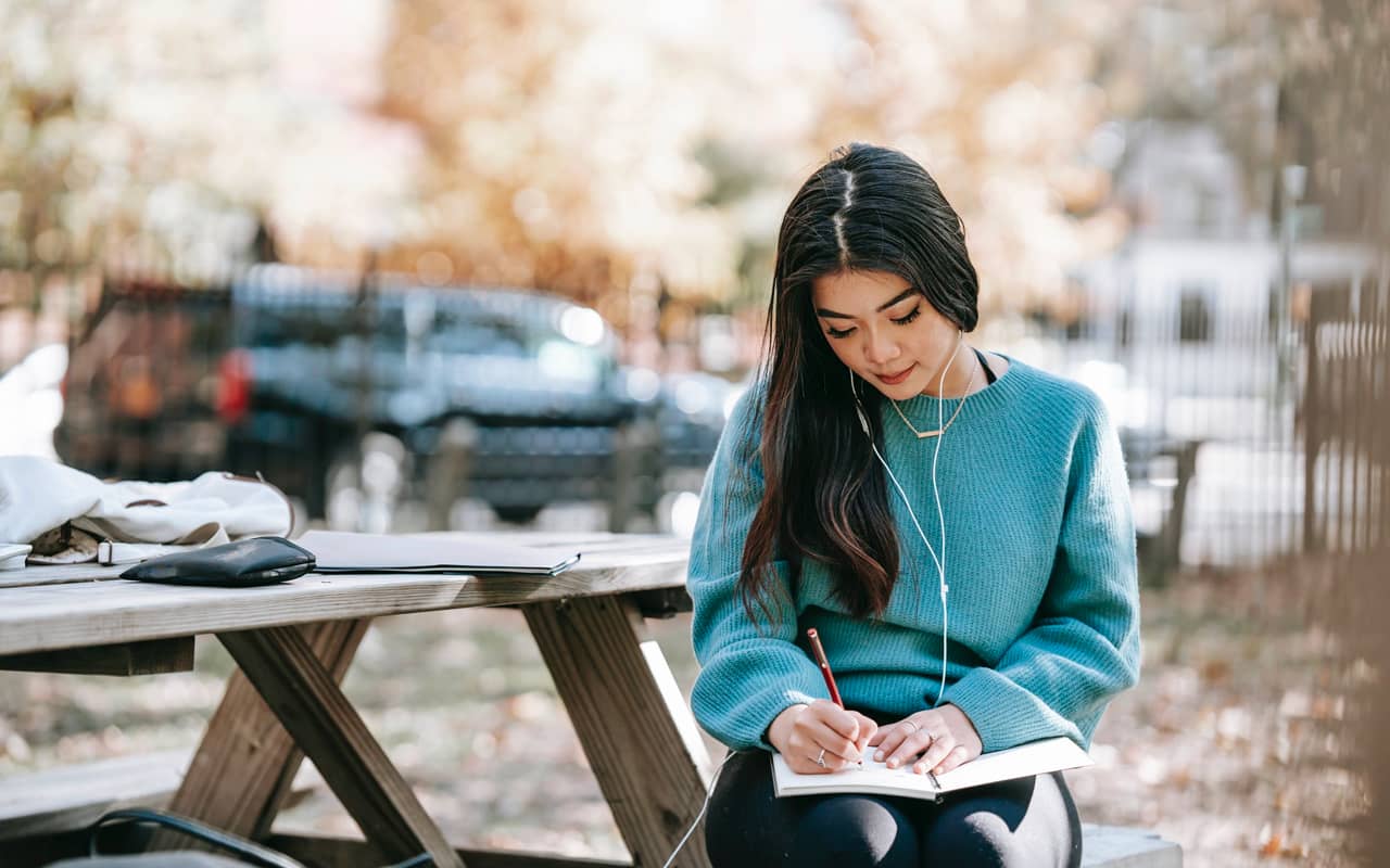 a woman is writing and listening