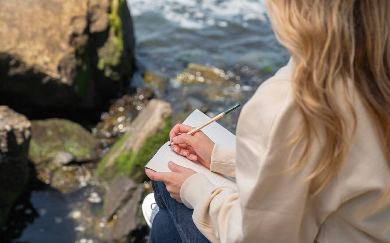 a woman is writing on her notebook