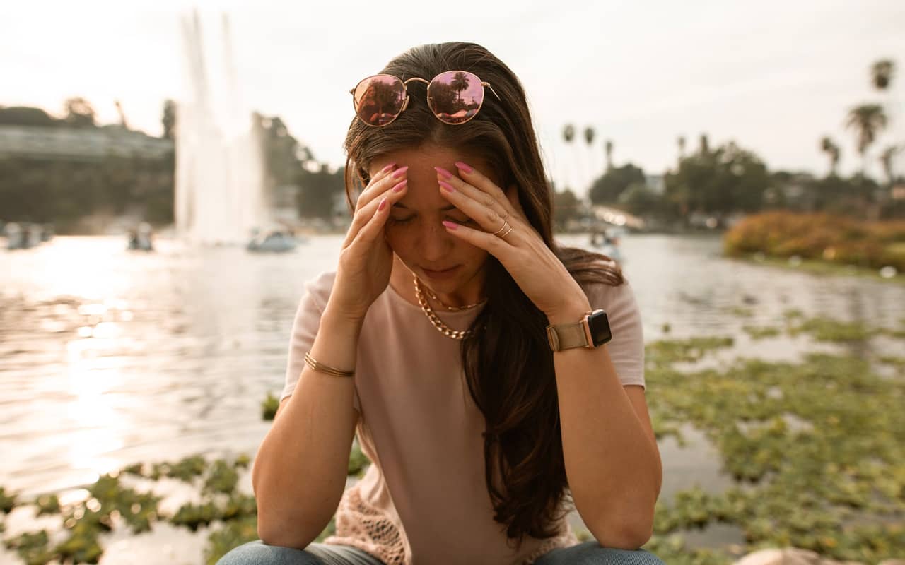 a women holds her hands in her head while suffering