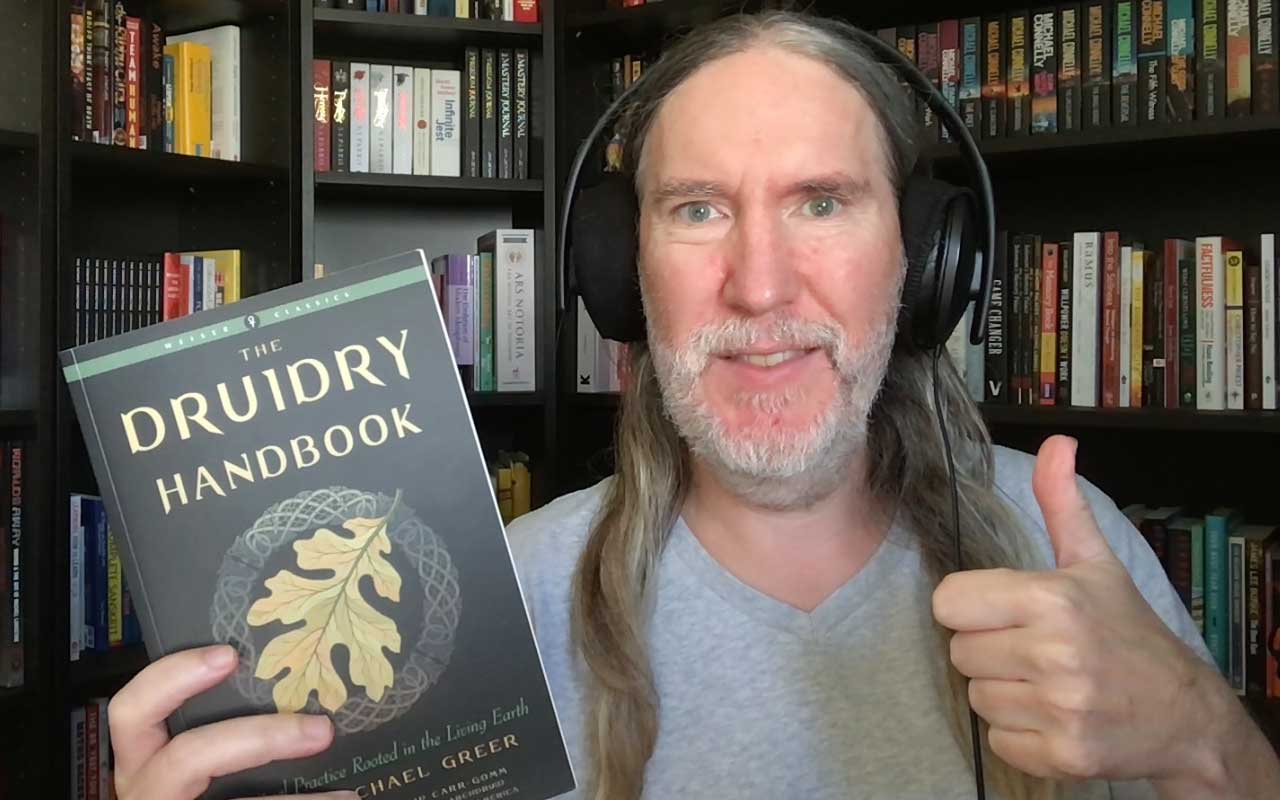 Anthony Metivier holding a copy of The Druidry Handbook by John Michael Greer