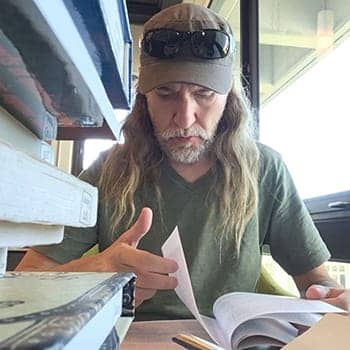 Anthony Metivier reading in a library