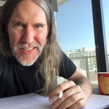 Anthony Metivier taking notes on the balcony while editing a book for note taking methods tutorial