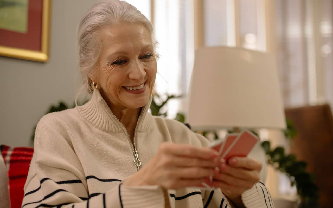 grey hair woman is playing cards