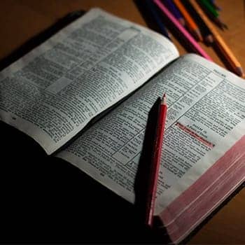 Image of an open Bible with a memory verse highlighted in red