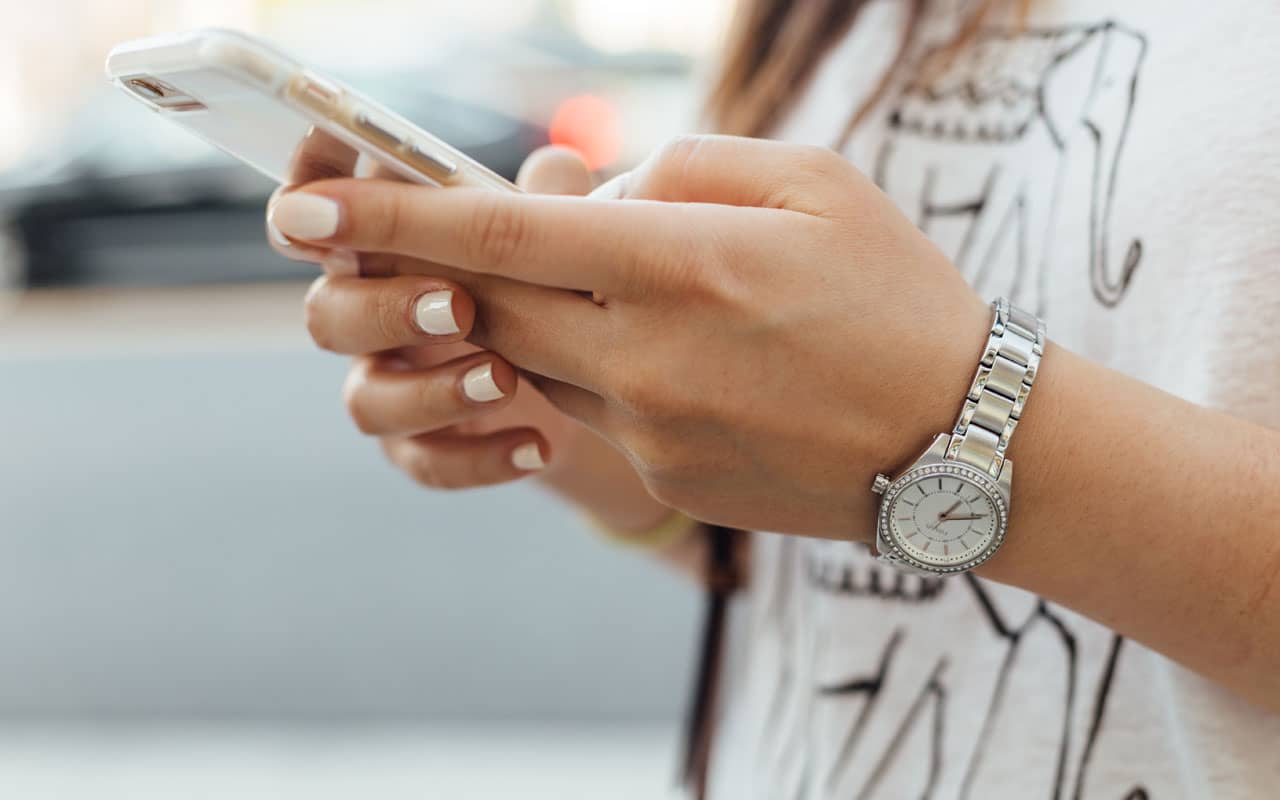 Woman holding phone. In a crisis, it's good to memorize important phone numbers.