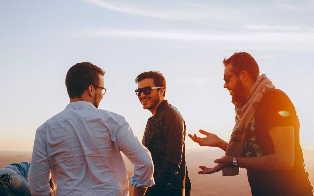 three man are talking with each other