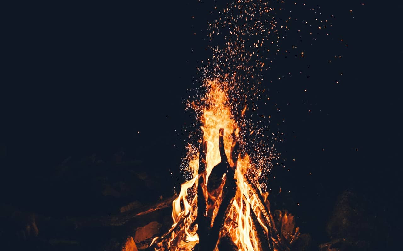 A bonfire burns in the darkness.
